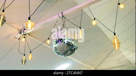 Boule disco. Une boule en miroir au plafond qui reflète la lumière colorée dans le club. Banque D'Images