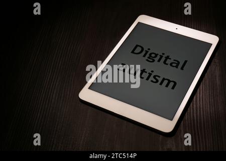 Tablette avec phrase Digital Autism sur table en bois, espace pour le texte. Comportement addictif Banque D'Images