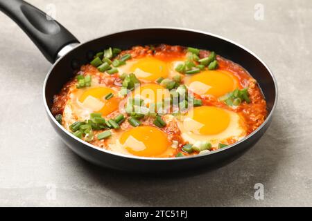 Délicieux Shakshuka dans la poêle sur la table gris clair, gros plan Banque D'Images