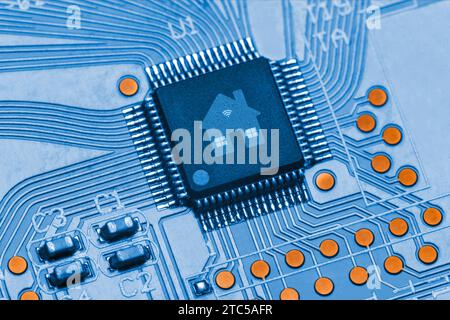 Microchip avec un logo Smart Home sur une carte de circuit imprimé bleue. Concept d'une maison intelligente informatisée avec connexion Wi-Fi Banque D'Images