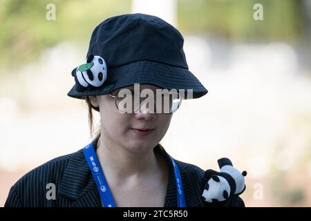 Dubaï, Émirats arabes Unis. 11 décembre 2023. Une femme porte des jouets en peluche panda sur ses vêtements sur le terrain de la COP28 de la Conférence des Nations Unies sur les changements climatiques. Les principaux thèmes de la Conférence des Nations Unies sur les changements climatiques de cette année incluent le financement des dommages causés par les changements climatiques. Crédit : Hannes P. Albert/dpa/Alamy Live News Banque D'Images