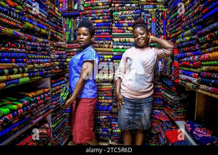 Les commerçants sont arrêtés pour une photo dans un magasin de tissus de la rue Biashara le 19 octobre 2023 à Nairobi, au Kenya. Afrowema (une marque sociale de mode éthique et durable née à Kibera, au Kenya, le plus grand bidonville d’Afrique, Afrowema contribue à l’autonomisation des artisans de cette communauté et crée de nouvelles opportunités d’emploi en utilisant des matériaux locaux neufs et usagés) a été fondée par Tatiana. Juste avant l’événement, Tatiana accompagnée d’Idah Odeka, une mannequin et activiste environnementale, a passé des jours à travailler avec une équipe de sept jeunes mannequins venus de différentes parties de Nairobi, leur enseignant à danser Banque D'Images