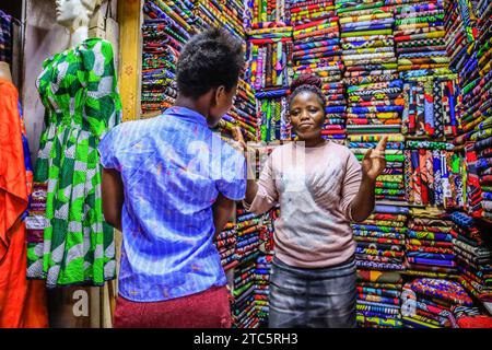 Les commerçants vendent leurs produits textiles dans un magasin de textile de la rue Biashara le 19 octobre 2023 à Nairobi, au Kenya. Afrowema (une marque sociale de mode éthique et durable née à Kibera, au Kenya, le plus grand bidonville d’Afrique, Afrowema contribue à l’autonomisation des artisans de cette communauté et crée de nouvelles opportunités d’emploi en utilisant des matériaux locaux neufs et usagés) a été fondée par Tatiana. Juste avant l’événement, Tatiana accompagnée d’Idah Odeka, une mannequin et activiste environnementale, a passé des jours à travailler avec une équipe de sept jeunes mannequins venus de différentes parties de Nairobi pour leur enseigner Banque D'Images