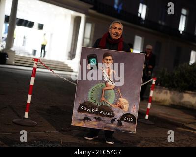 L’artiste politique Kaya Mar avec une peinture du Premier ministre Rishi Sunak et de l’ancien Premier ministre Boris Johnson en dehors de l’enquête britannique sur la Covid-19 à Dorland House à Londres, au cours de sa deuxième enquête (module 2) explorant la prise de décision et la gouvernance politique au Royaume-Uni. Date de la photo : lundi 11 décembre 2023. Banque D'Images