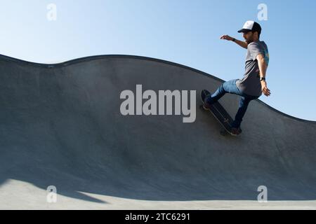 Un jeune homme effectuant du skateboard dans un parc de skateboard en plein air Banque D'Images