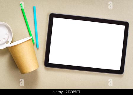 Maquette avec tablette et tasse en papier jetable et pailles.Relax au travail et gérer le concept des niveaux de stress Banque D'Images