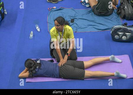 Guwahati, Inde. 06 décembre 2023. Un officiel repousse le dos d'un joueur dans le cadre de la routine d'échauffement lors de la deuxième journée du tournoi de badminton Super 100 Yonex-Sunrise Guwahati Masters à Guwahati. Le Guwahati Masters 2023 est un tournoi BWF Super 100 qui se déroule du 5 au 10 décembre 2023. Il est doté d ' un prix total de 100 000 dollars. (Photo de Biplov Bhuyan/SOPA Images/Sipa USA) crédit : SIPA USA/Alamy Live News Banque D'Images