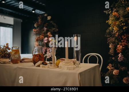 Réglage de table élégant, propre et facile pour fête intérieure, réception de mariage avec luxe, grande décoration de fleur sur le mur. Table d'événement spécial mise en place avec Banque D'Images