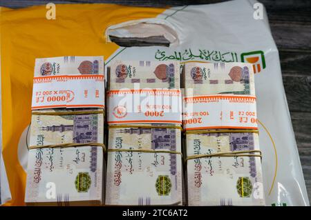 Le Caire, Egypte, novembre 26 2023 : piles et piles d'argent de l'Egypte des milliers de livres billets de banque billets de 200 EGP LE, avec un sac d'argent de Natio Banque D'Images