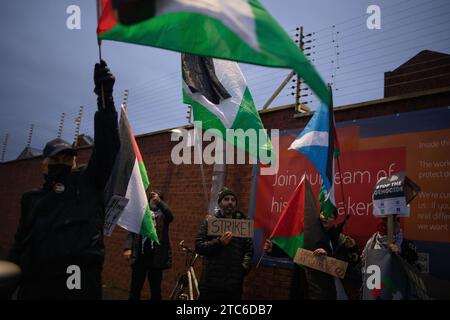 Glasgow, Royaume-Uni, 11 décembre 2023. Un rassemblement pro-palestinien se réunit devant la porte d'entrée de BAE Systems à Govan pour protester contre leur implication dans la marine britannique et l'infrastructure militaire, au moment où le génocide se déroule à Gaza, à Glasgow, en Écosse, le 11 décembre 2023. Crédit photo : Jeremy Sutton-Hibbert/ Alamy Live News. Banque D'Images