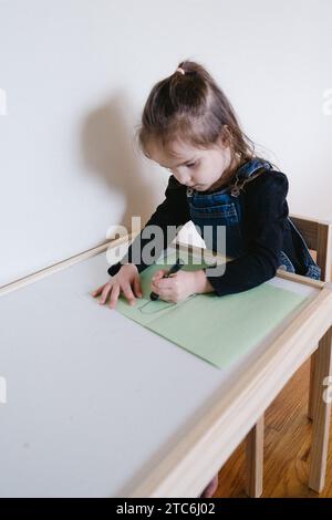 Dessin d'enfant à la table d'art. Banque D'Images