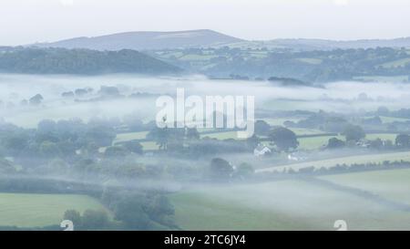 Campagne vallonnée entourée de brume près de Chagford dans le parc national de Dartmoor, Devon, Angleterre. Automne (septembre) 2023. Banque D'Images