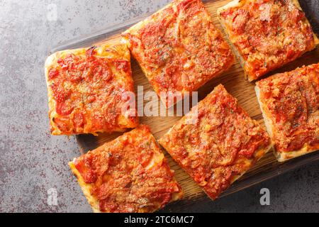 Sfincione focaccia cuit au four typique très doux et assaisonné avec des tomates, oignons, anchois, fromage, origan et chapelure de pain closeup sur le boa en bois Banque D'Images