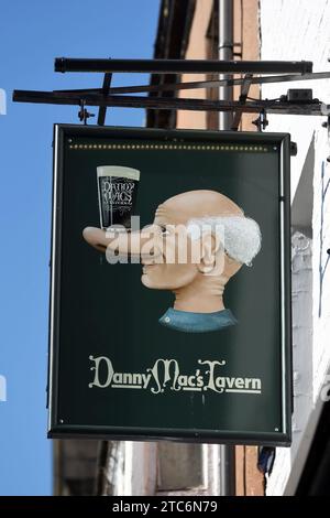 Panneau suspendu pour Danny Mac's Tavern, Pub, Bar ou public House, illustré avec un homme âgé avec une pinte de bière équilibrée sur son long nez Liverpool Banque D'Images