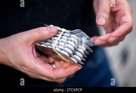 Berlin, Allemagne. 24 novembre 2023. Vet Jeanette Klemmt tient des plaquettes thermoformées de comprimés lors d’une consultation dans son cabinet vétérinaire mobile. Le projet HundeDoc traite principalement les animaux appartenant à des jeunes et des jeunes adultes démunis qui vivent principalement dans la rue ou dans les espaces publics et reçoivent un soutien socio-éducatif. Crédit : Monika Skolimowska/dpa/Alamy Live News Banque D'Images