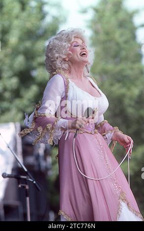 Superstar Dolly Parton se produisant sur scène lors d'un concert lors de sa tournée Midwest 1978, sa tête est inclinée vers l'arrière et elle a un bon rire. Banque D'Images