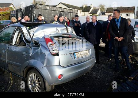 Le Taoiseach Leo Varadkar (à droite) voit une voiture qui a été endommagée par un arbre dans le village de Leitrim à Co Leitrim, après une tornade et des vents violents dimanche, des arbres ont aplati, arraché un toit d'un bâtiment et laissé des débris éparpillés dans une rue. Date de la photo : lundi 11 décembre 2023. Banque D'Images