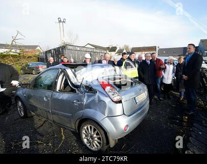 Le Taoiseach Leo Varadkar (à droite) voit une voiture qui a été endommagée par un arbre dans le village de Leitrim à Co Leitrim, après une tornade et des vents violents dimanche, des arbres ont aplati, arraché un toit d'un bâtiment et laissé des débris éparpillés dans une rue. Date de la photo : lundi 11 décembre 2023. Banque D'Images