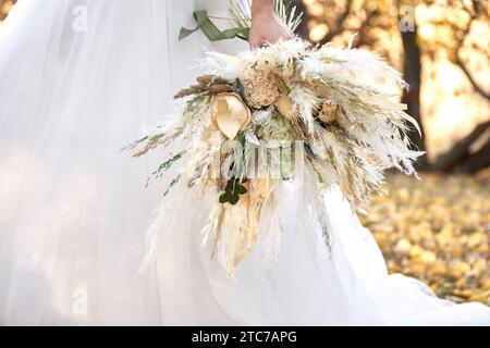 mains de la mariée tenant beau bouquet d'automne Banque D'Images