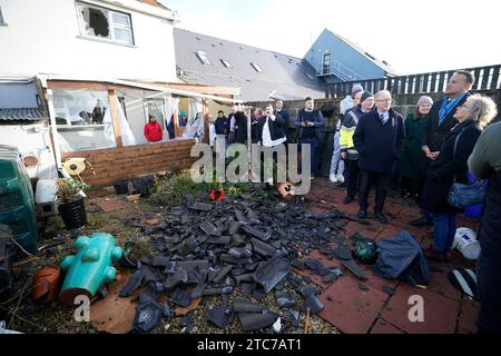 Le Taoiseach Leo Varadkar (à droite) voit les dégâts causés à une maison et à un jardin dans le village de Leitrim à Co Leitrim, après une tornade et des vents violents sur des arbres rasés dimanche, arraché un toit d'un bâtiment et laissé des débris dispersés dans une rue. Date de la photo : lundi 11 décembre 2023. Banque D'Images