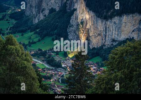 Belle vue depuis le village de montagne de Wengen et la vallée illuminée de Lauterbrunnen au crépuscule dans le canton de Berne, Suisse Banque D'Images