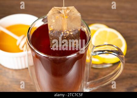 Préparation du thé à partir d'un sachet de thé dans une tasse en verre. Banque D'Images