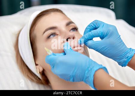 cosmétologue fait des injections pour agrandir les lèvres d'une belle femme. injections de beauté. Banque D'Images