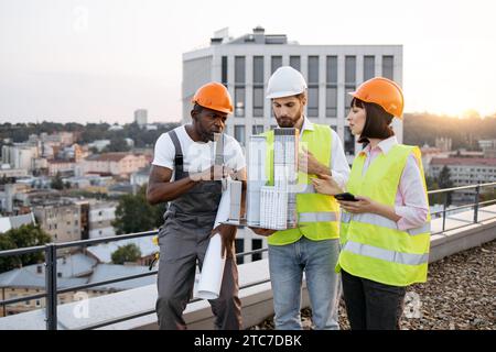 Ingénieurs civils discutant du projet commun ensemble sur le toit Banque D'Images