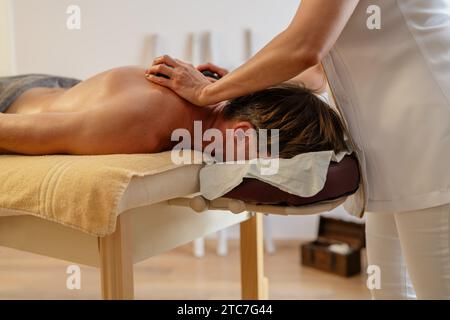 Femme massothérapeute appliquant une pression avec les mains sur le dos du client masculin. Image conceptuelle de l'hôtel Wellness Banque D'Images
