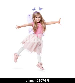 Mignonne petite fille en costume de fée avec des ailes violettes sautant sur fond blanc Banque D'Images