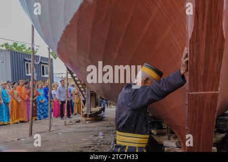 12 décembre 2023, Makassar, Sulawesi du Sud, Indonésie : un aîné exécute un rituel traditionnel dans la tradition annyorong lopi ou pousse un bateau dans la zone côtière de la ville de Makassar, le lundi 11 2023 décembre. Le plan est que ce bateau de pignon sera défilé en mer impliquant la tradition annyorong lopi, où ils poussent et tirent le bateau à l'aide de poulies pour lui permettre de naviguer sur la mer. Un moment historique qui reflète la riche culture et la convivialité du peuple Bugis. (Image de crédit : © Moh Niaz Sharief/ZUMA Press Wire) USAGE ÉDITORIAL SEULEMENT! Non destiné à UN USAGE commercial ! Banque D'Images