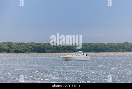 deux personnes pêchant à l'arrière d'un bateau avec l'île de shelteri en arrière-plan Banque D'Images