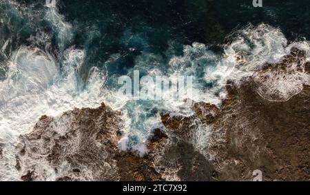 Vue aérienne des vagues de mer turbulentes rencontrant la côte rocheuse créant de l'écume sur l'île de fuerteventura Banque D'Images