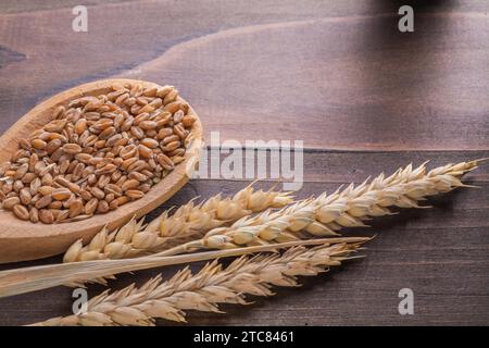 Cuillère en bois avec des cors et des épis de blé sur planche vintage Banque D'Images