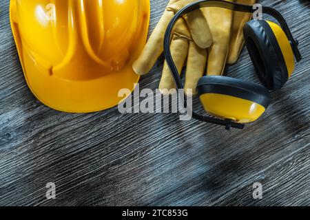 Gants de sécurité de construction casque cache-oreilles sur planche de bois Banque D'Images