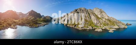 Vue panoramique drone du Nusfjord à Lofoten, Norvège, capture les eaux bleues vibrantes et les falaises accidentées sous le soleil d'été, avec une dispersion de tra Banque D'Images