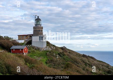 Un phare pittoresque se dresse au sommet d'une colline surplombant un plan d'eau bleu tranquille à Varberg, en Suède Banque D'Images