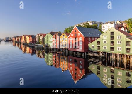 Coucher de soleil sur la rivière Nidelva avec des maisons en bois emblématiques le long des rives lors d'une soirée d'été à Trondheim, Norwa Banque D'Images