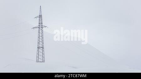 Une photo d'une tour de transmission dans une montagne complètement blanche couverte de neige Banque D'Images