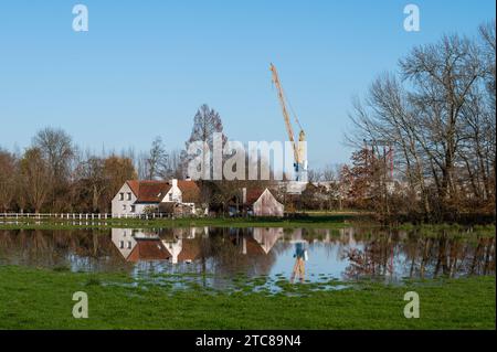 Imde, Meise, région flamande du Brabant, Belgique, novembre 28, 2023 - Construction d'une grue et de maisons se reflétant dans une prairie inondée crédit : Imago/Alamy Live News Banque D'Images