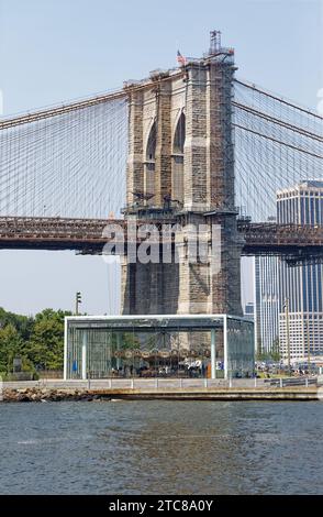 Jane’s Carousel se dresse à l’ombre du pont de Brooklyn. L’amusement pour enfants entouré de verre a été déplacé de Youngstown, Ohio. Banque D'Images