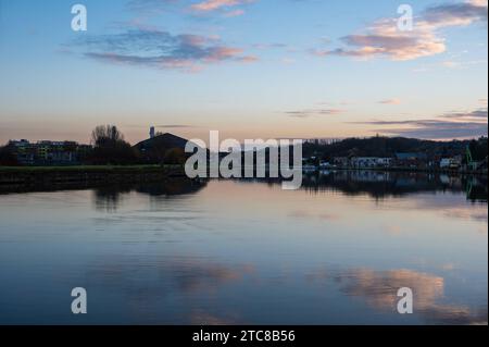 Vilvoorde, région du Brabant flamand, Belgique, 28 novembre 2023 - reflets colorés de maisons résidentielles dans le canal au crépuscule Credit : Imago/Alamy Live News Banque D'Images