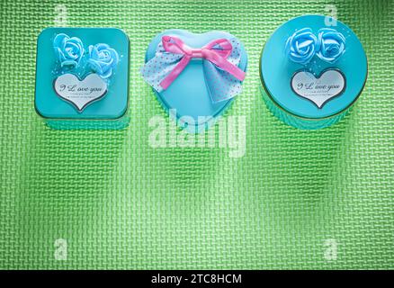Composition de boîtes-cadeaux en métal bleu emballées sur le concept de vacances de fond vert Banque D'Images