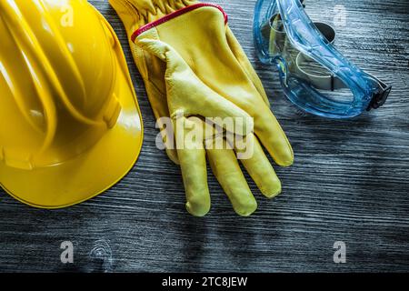 Casquette de sécurité gants en cuir lunettes sur planche en bois vintage Banque D'Images