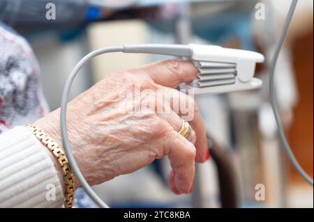 Gros plan de la main d'une patiente âgée à l'aide d'un oxymètre de pouls. Photo de haute qualité Banque D'Images