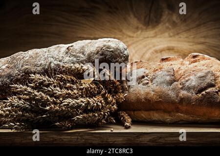 Deux miches de pain et un paquet d'oreilles sur du vieux bois Banque D'Images