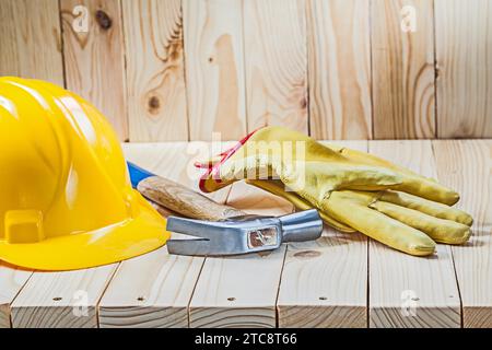 Gants de travail jaunes griffe marteau et casque sur un fond en bois Banque D'Images