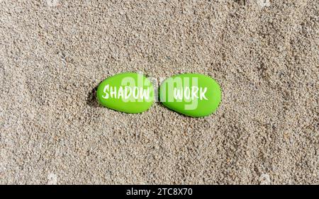 Symbole de psychologie du travail d'ombre. Mots conceptuels Shadow travaille sur une belle pierre verte. Beau fond de plage de sable. Le concept de travail d'ombre en psychologie. Co Banque D'Images