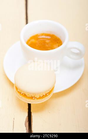Macarons colorés avec café expresso sur table en bois blanc Banque D'Images