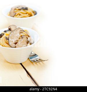 Les pâtes spaghetti italien et des champignons sauvages sur table en bois rustique Banque D'Images